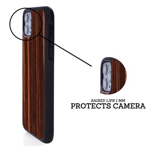 May include: A brown wood phone case with a black border. The case has a raised lip around the camera to protect it from scratches. "RAISED LIPS 1 MM PROTECTS CAMERA" is printed on the case.
