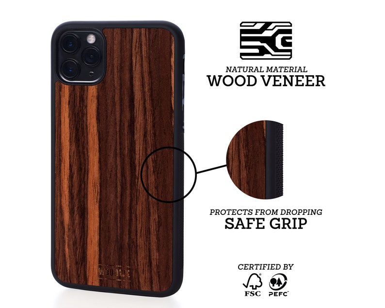 May include: A brown wood veneer iPhone case with a black border and a raised camera bump. The case has a textured surface and a safe grip. The case is certified by FSC and PEFC.
