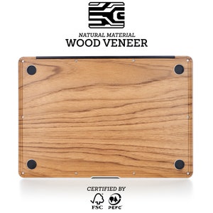 May include: A laptop with a wood veneer finish. The laptop is made from natural materials and is certified by the FSC and PEFC. The laptop has a wood grain pattern and is a light brown color.