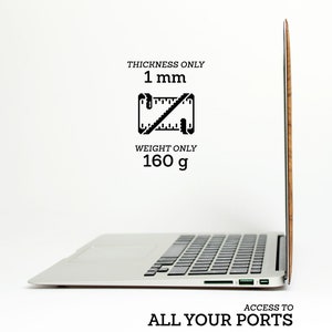 May include: A wooden laptop skin in a light brown color. The skin is thin, only 1 mm thick and weighs 160 grams. The skin is shown on a silver laptop with a black keyboard. The text "ACCESS TO ALL YOUR PORTS" is at the bottom of the image.