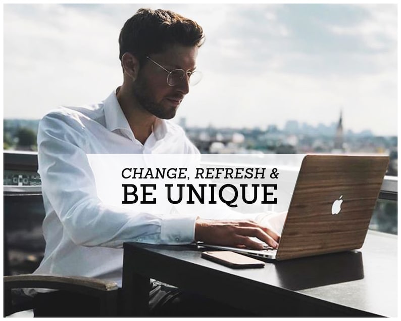 May include: A person working on a laptop computer with a wooden cover. The laptop is on a table with a smartphone. The text "CHANGE, REFRESH & BE UNIQUE" is visible on the laptop.