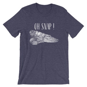May include: A navy blue t-shirt with a white alligator graphic and the text "OH SNAP!" printed on the front.