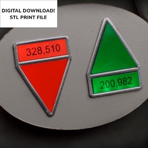 Puede incluir: Dos contadores digitales de forma triangular con borde plateado. El contador rojo muestra el número 328.510 y el contador verde muestra el número 200.982.