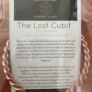 Op de afbeelding: Een koperen draad armband met een kaart waarop "The Lost Cubit" staat en de eigenschappen ervan worden beschreven. De kaart stelt dat de armband is afgeleid van de som van de polaire en equatoriale omtrekken van de aarde gedeeld door de lichtsnelheid. Het stelt ook dat de armband resoneert met kosmische energiefrequenties en aardse energiefrequenties, en de geheime sleutel is tot buitengewone gezondheid en extreme levensduur.