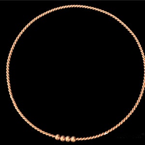 May include: A copper wire bracelet with three small copper beads.
