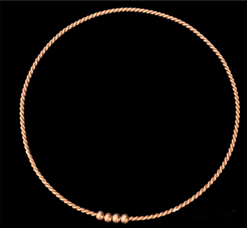 Puede incluir: Un brazalete de alambre de cobre con tres peque&ntilde;as cuentas de cobre.
