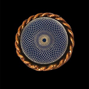 Op de afbeelding: Een koperkleurige ring met een blauw en wit mandala-ontwerp. De mandala is een geometrisch patroon met een centrale cirkel en stralende lijnen.