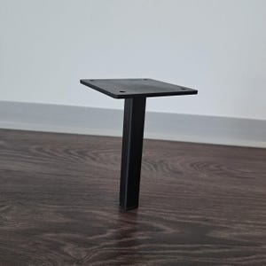 Peut inclure: Un pied de meuble en métal noir avec une plaque de montage carrée et un support rectangulaire. La jambe est conçue pour être fixée à une table ou à un autre meuble. La jambe mesure environ 25 cm de haut.