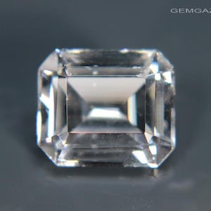 May include: A clear, faceted, emerald cut gemstone with a square shape.
