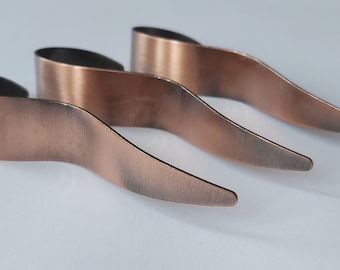 May include: Three copper-colored metal hair clips with a wavy design.