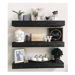 Floating Shelves made from wood with a standard 3.5 in. H and 6 in. D. Custom sizes available. Stain color, quantity and length can be selected from the drop-down on the listing. Shelves pictured are 30 in. L and stained Ebony.