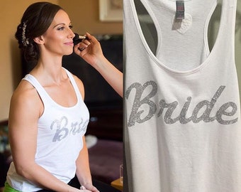 Op de afbeelding: Wit tanktop met het woord "Bride" in zilveren glitterletters.
