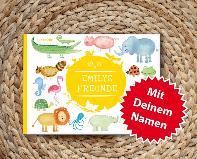 May include: A colorful children's book with the title "Emilys Freunde" and the text "Mit Deinem Namen" on a red starburst. The book features illustrations of animals including a flamingo, a turtle, a lion, an elephant, a rhinoceros, a seahorse, a raccoon, a crocodile, a frog, a ladybug, an octopus, and a pig.
