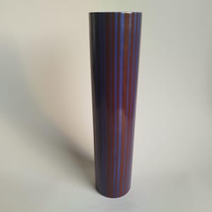May include: A tall, cylindrical vase with a striped pattern in shades of brown and blue.