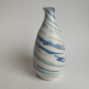 May include: A white ceramic vase with a blue and green swirl pattern.