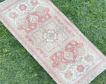 Puede incluir: Una alfombra de estilo vintage con un patrón floral en tonos rosa, beige y crema. La alfombra tiene un diseño detallado con detalles intrincados y un borde.