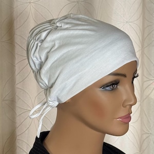 May include: White cotton chemo cap with a gathered top and a tie at the back.