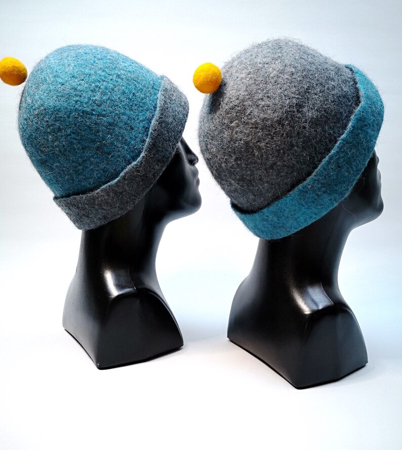 Rough edged graphite grey or teal blue bobble close fitting beanie hat natural wool saunaoutdoors charcoal gray cloche with a orange bobble