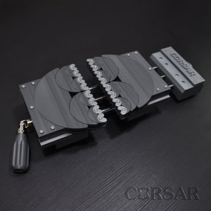 May include: A black metal clamp with a series of interlocking gears. The clamp is open and has a handle on the side. The text "CIRSAR" is printed on the side of the clamp.