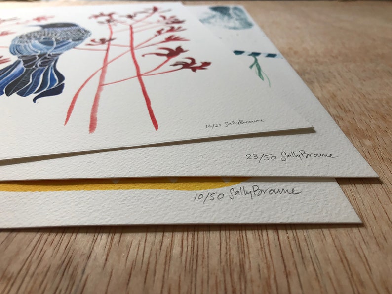 May include: Three signed art prints stacked on top of each other. The top print features a blue bird with red flowers. The middle print has the number "23/50" and the bottom print has the number "10/50". All prints are signed "Sally Browne".