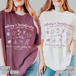 May include: Two white t-shirts with pink text and graphics. The text on the shirts reads "Kelsey's Bachelorette has entered the villa" and "Fort Lauderdale, FL Mar 2025". The graphics include palm trees, sunglasses, a cocktail glass, a phone, and a lipstick.