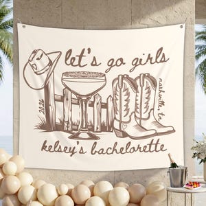 Peut inclure: Tapisserie cr&egrave;me avec une illustration marron repr&eacute;sentant un chapeau de cowboy, un cocktail, une cl&ocirc;ture et des bottes de cowboy. Le texte dit "let's go girls", "Nashville, TN" et "kelsey's bachelorette."