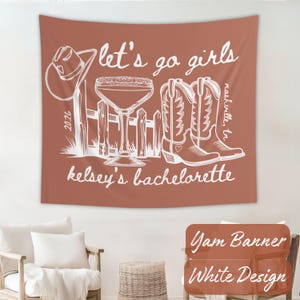 Peut inclure: Une tapisserie terracotta avec une illustration blanche. Elle repr&eacute;sente un chapeau de cowboy, un cocktail, une cl&ocirc;ture et des bottes de cowboy. Le texte dit "let's go girls", "kelsey's bachelorette" et "nashville, tn."