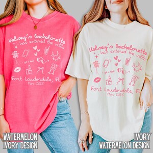 May include: Two pink and ivory t-shirts with a white graphic design. The design includes the text "Kelsey's Bachelorette has entered the villa", a palm tree, a phone, a lipstick, sunglasses, a cocktail, a bow, and champagne glasses. The text "Fort Lauderdale, FL" and "Mar 2025" are also included in the design.
