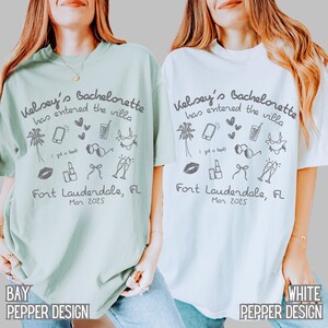 May include: Two light blue and white t-shirts with the text "Kelsey's Bachelorette has entered the villa" and a variety of illustrations including palm trees, sunglasses, lipstick, and champagne glasses. The text "Fort Lauderdale, FL" and "Mar 2025" are also printed on the shirts.