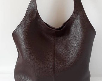 May include: A brown leather tote bag with a single strap. The bag has a slouchy, relaxed look.