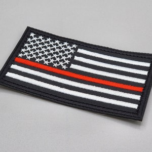 Può includere: Toppa di bandiera americana in bianco e nero con un'unica striscia rossa al centro. La toppa è ricamata e ha un bordo nero.