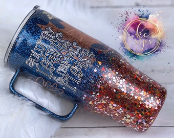 May include: A blue and copper glitter tumbler with a handle. The tumbler has the text "Autumn Leaves & Game Day & Rainbows Please" written on it.