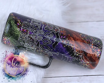 May include: A black and silver tumbler with a glittery finish. The tumbler has a spiderweb design and the text "It's the season to be spooky".