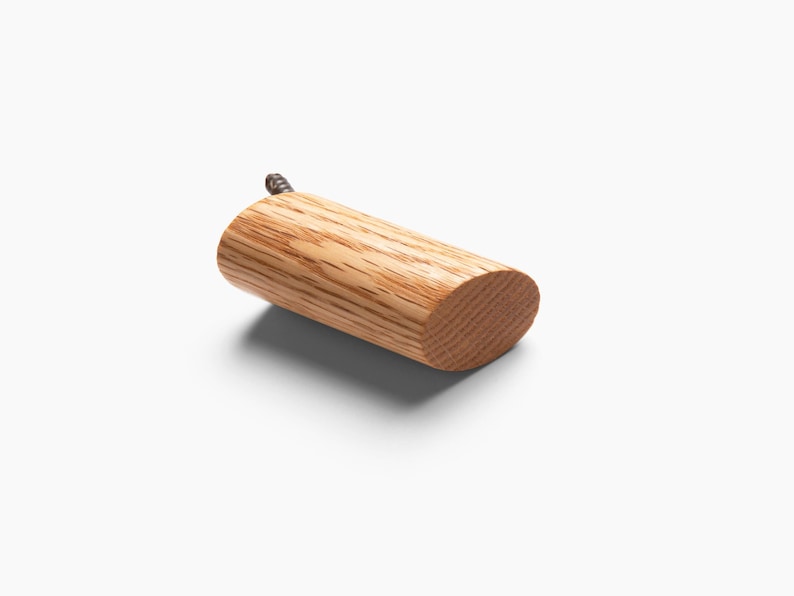 May include: A wooden hook with a rounded end and a screw for mounting. The hook is made of light brown wood with a natural grain pattern.