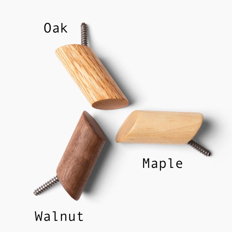 May include: Three wooden wall hooks in oak, maple, and walnut. Each hook has a screw for mounting.