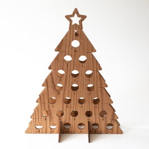Puede incluir: Calendario de adviento de &aacute;rbol de Navidad de madera con 25 c&iacute;rculos numerados. El &aacute;rbol est&aacute; hecho de madera marr&oacute;n claro y tiene una estrella en la parte superior.