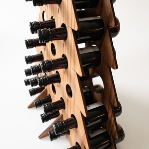 Puede incluir: Un expositor de vino de madera con forma de &aacute;rbol de Navidad con 24 ranuras para botellas de vino. El expositor est&aacute; hecho de madera natural y tiene un aspecto r&uacute;stico. Las botellas no est&aacute;n incluidas.