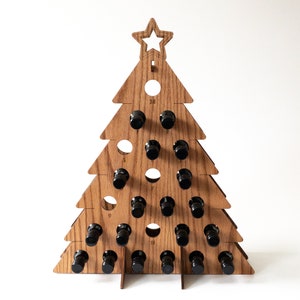 May include: Wooden Christmas tree-shaped wine bottle holder with 24 slots for mini bottles. The tree is made of light brown wood and has a star on top.