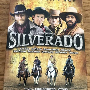 May include: DVD case for the movie "Silverado" featuring a group of men in cowboy hats. The title is in large, bold letters. The case also includes the names of the actors and a quote from Roger Ebert.