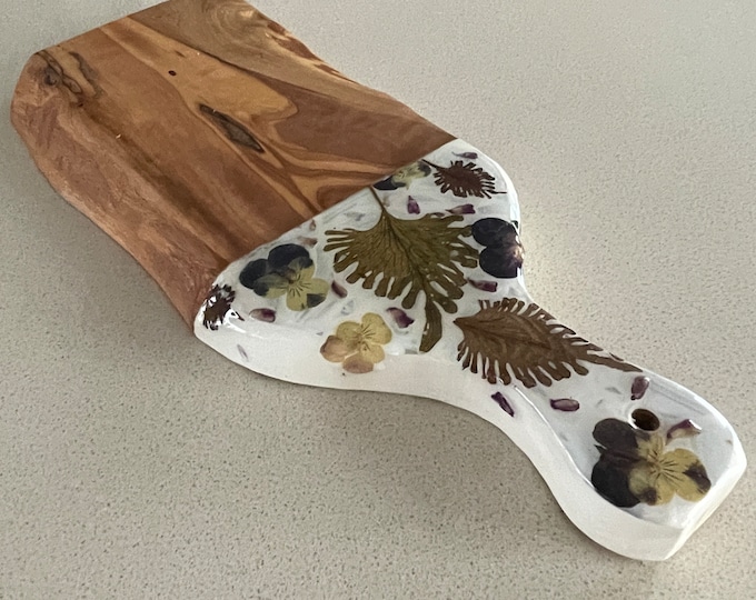 Olivewood serving board with dried leaves, violet and lavender flowers