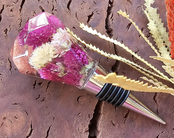 Resin wine bottle stoppers with embedded elements
