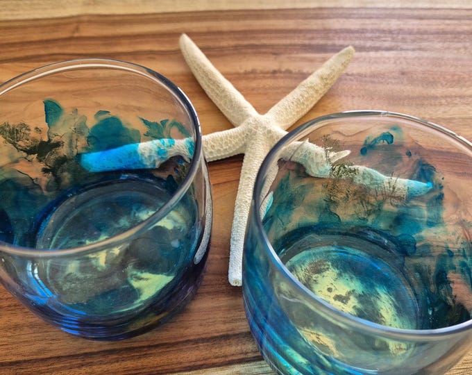Glass tumblers featuring blue and gold alcohol ink and resin artwork