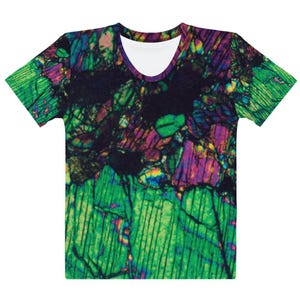 May include: Women's t-shirt with a colorful abstract print featuring shades of green, purple, and black. The print resembles a close-up of a rock or mineral.
