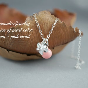 May include: A silver chain necklace with a pink coral pearl and a silver flower charm.  "Personalize Jewelry Choice of pearl color Shown - pink coral"