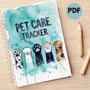 Może przedstawiać: Spiralny notatnik z napisem "PET CARE TRACKER" i akwarelowymi odciskami łap. Okładka ma turkusowy wzór zmywania akwarelą. Dwa ołówki leżą obok notatnika na drewnianej powierzchni.