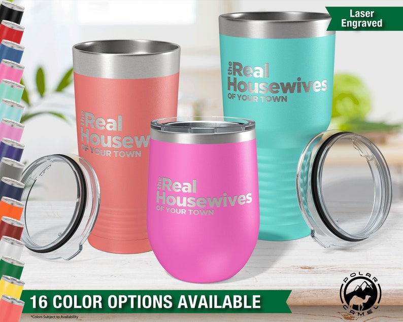 May include: Three stainless steel tumblers with laser engraved text that reads "The Real Housewives of Your Town". The tumblers are in pink, turquoise, and coral colors. The tumblers are on a wooden surface.