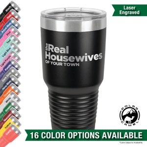 May include: A black stainless steel tumbler with a silver lid and a laser engraved design that says "the Real Housewives of Your Town". The tumbler is surrounded by a variety of colored tumblers, each with a different color lid. The text "16 COLOR OPTIONS AVAILABLE" is displayed below the tumbler. The text "Laser Engraved" is displayed in the upper right corner of the image.
