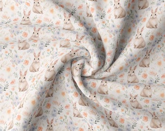 May include: White fabric with a repeating pattern of watercolor bunnies and flowers. The bunnies are light brown and the flowers are in shades of pink, blue, and orange.