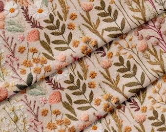 May include: A beige fabric with an embroidered floral pattern. The pattern features various shades of brown, pink, and yellow flowers, leaves, and stems.