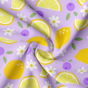 May include: A purple fabric with a repeating pattern of yellow lemons, white daisies, and purple blueberries. The fabric is textured and has a slightly crinkled appearance.